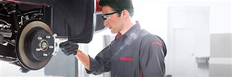 Technician working on a Nissan car in an official service center