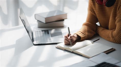 Persona che studia con libri e tablet, simbolo di preparazione ai concorsi