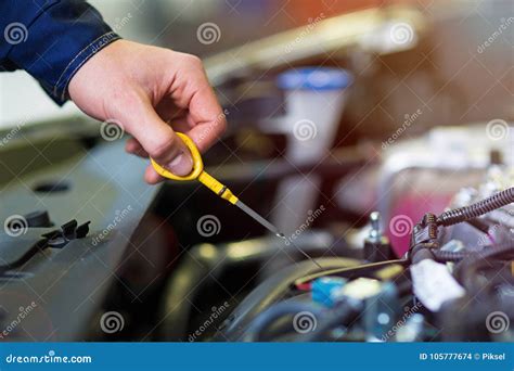 Meccanico che controlla l'olio motore