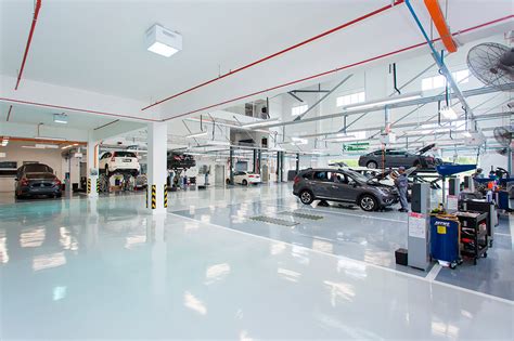 Interno di un'officina moderna con diverse auto in riparazione