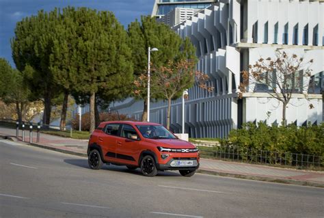 Dacia Spring in un contesto urbano, con indicazioni delle nuove specifiche tecniche