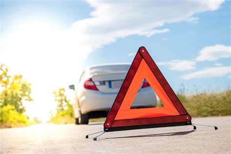 triangolo di sicurezza posizionato dietro un'auto ferma su strada