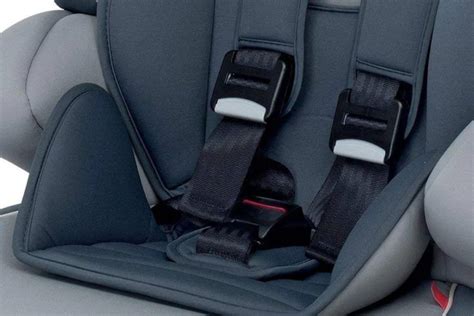 Bambino in seggiolino auto con cinture di sicurezza allacciate correttamente