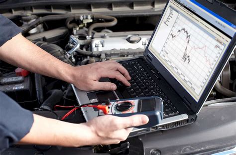Un tecnico che collega un computer diagnostico all'auto