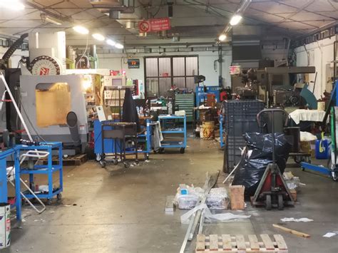 Interni di un'officina meccanica con un'auto in fase di controllo