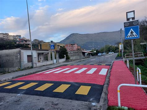 Una strada urbana con attraversamenti pedonali e traffico