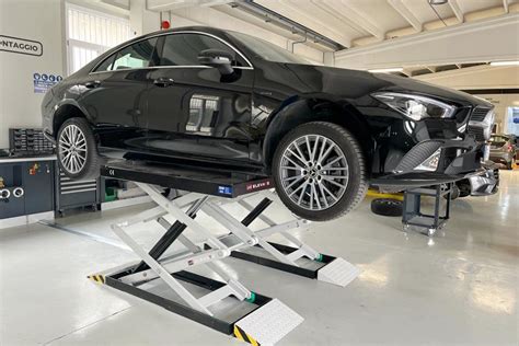 Officina meccanica con un'auto su un ponte sollevatore