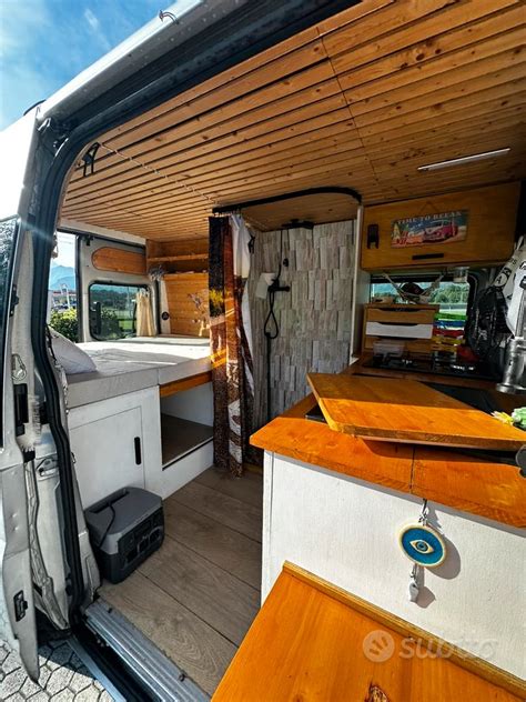 Interno di un Ford Transit Custom camperizzato con letto e cucina