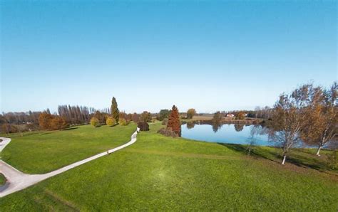 Parco urbano con alberi, un lago e persone che si rilassano
