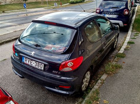 Veduta frontale e laterale della Peugeot 206 che mostra le sue linee distintive e la colorazione azzurro metallizzato