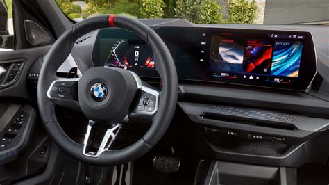 Interni della BMW Serie 1: plancia orientata al guidatore e schermi digitali