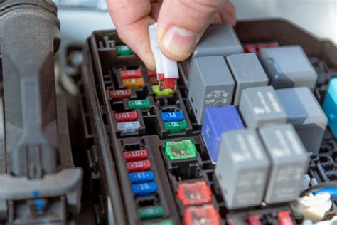 Meccanico che controlla un fusibile in un vano motore