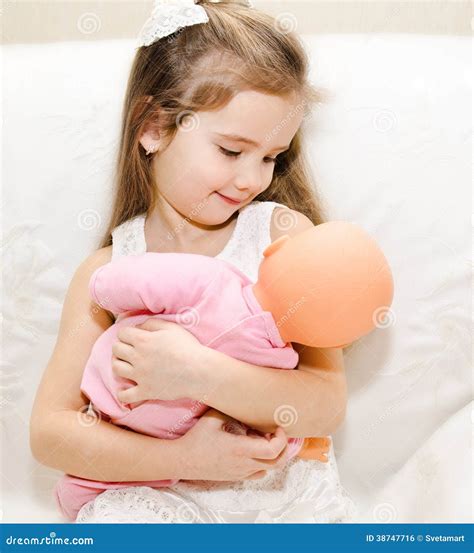 Bambina che gioca con una bambola Corolle