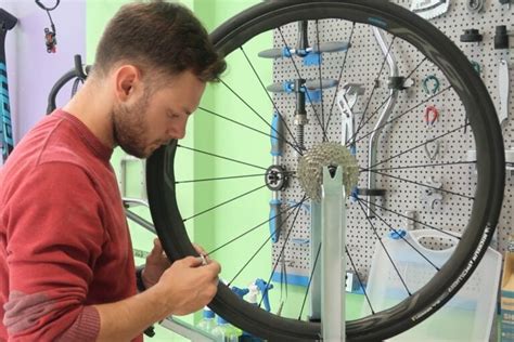 Persona che fatica a rimuovere un copertone da una ruota di bicicletta