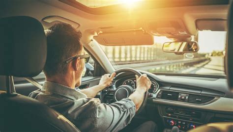 Persona che guida un'auto con un sorriso, simboleggiando il comfort