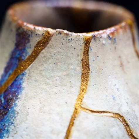 Un vaso rotto le cui crepe sono state riparate con oro, ispirandosi alla tradizione giapponese del Kintsugi, che simboleggia la bellezza delle imperfezioni
