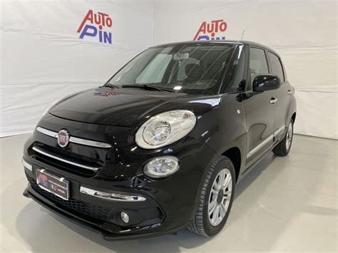 Fiat 500L in primo piano con concessionaria Autoingros Piacenza sullo sfondo