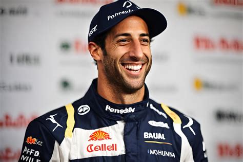 Daniel Ricciardo sorride accanto alla sua Renault