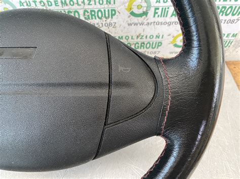 volante sportivo in pelle nera con cuciture rosse