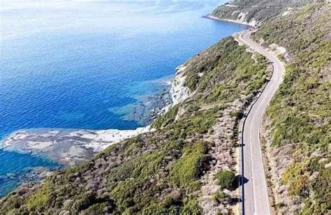 Una Mercedes SLK su una strada panoramica costiera con il tettuccio aperto