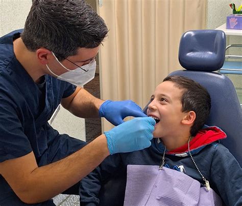 Dentista in camice mentre esegue un controllo