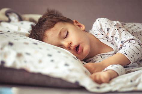 Bambino che dorme sereno in un letto