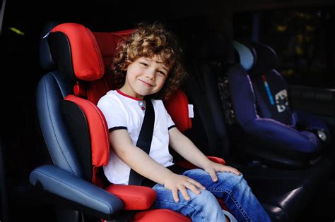 Bambino in auto con seggiolino e cinture di sicurezza allacciate