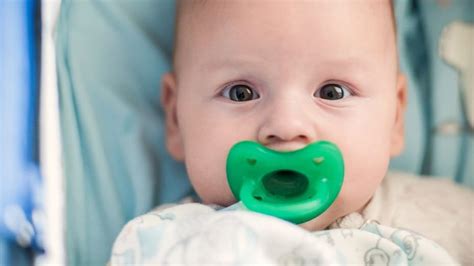 Bambino con ciuccio e guance arrossate