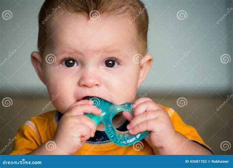 Bambino che mastica un anello da dentizione