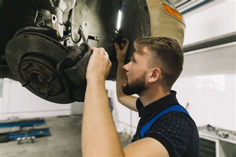 Tecnico che ispeziona il sistema di sospensione di un'automobile