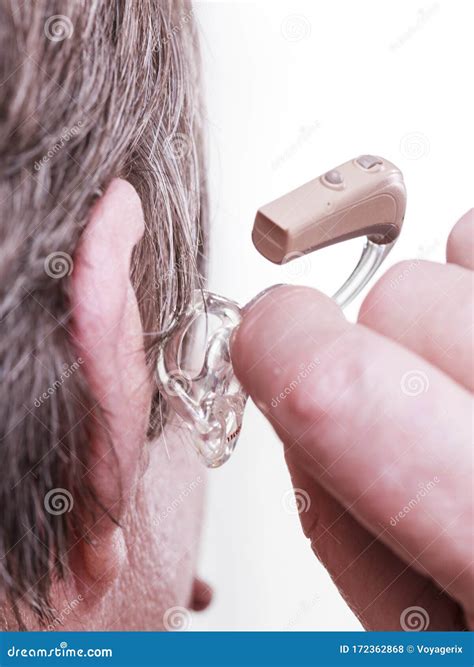 Persona anziana che ascolta con un apparecchio acustico