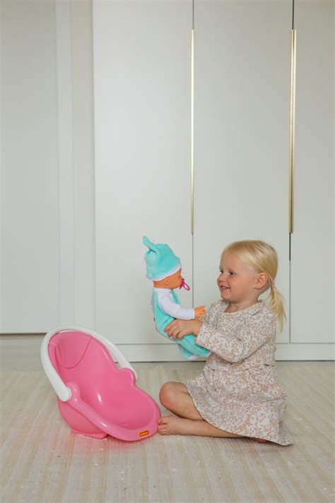 Bambina che gioca con un'auto elettrica rosa