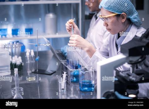 Studenti che lavorano in laboratorio con microscopi e provette