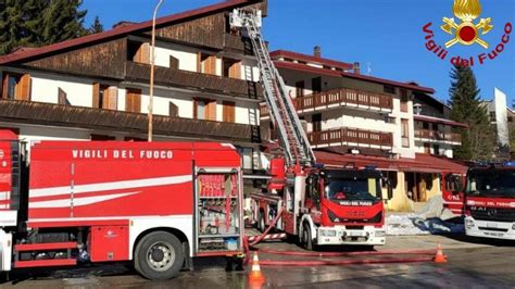 SUV in fiamme con vigili del fuoco che spengono l'incendio